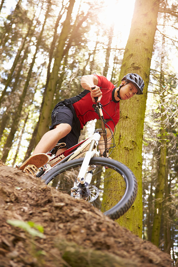 Man Riding Mountain Bike Through Woods