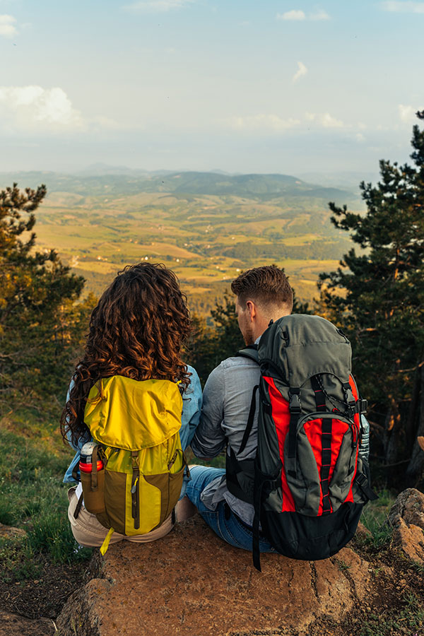 Shot of an attractive young couple taking a break while trekking in the mountains
