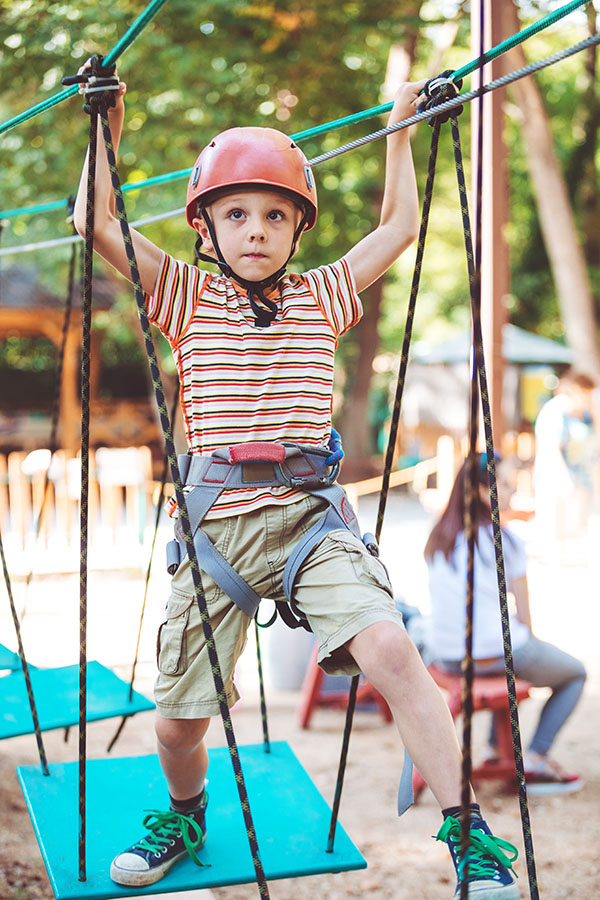 little boy make climbing in the adventure park. Concept of sport life.